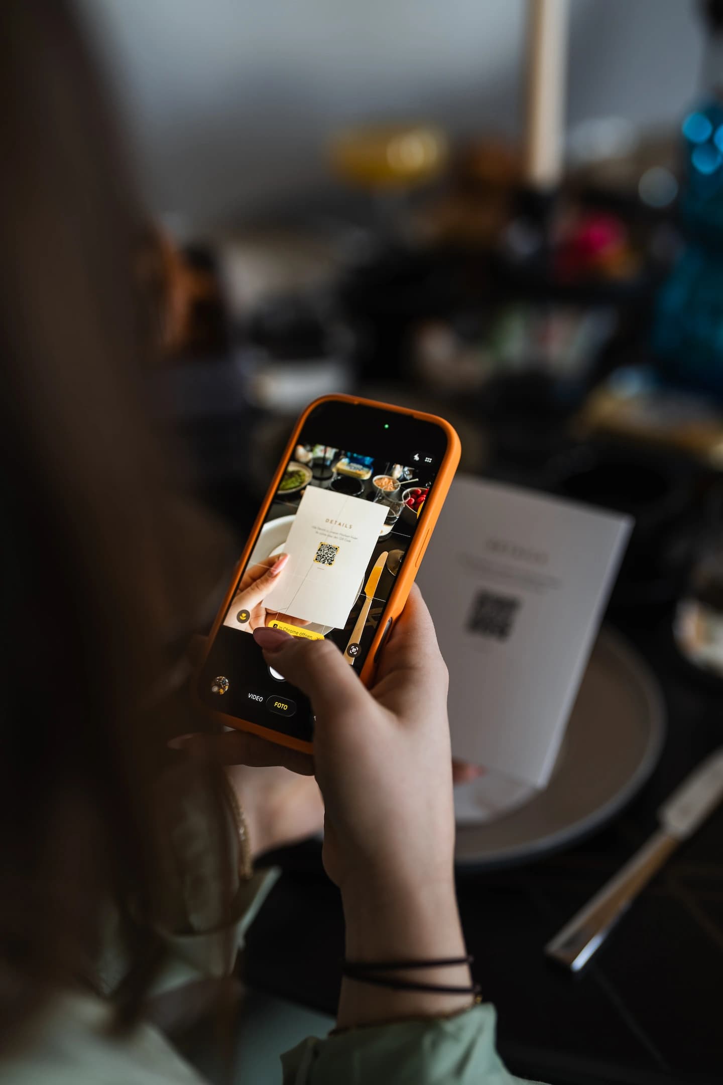 Hochzeitsgast scannt mit dem Smartphone den QR-Code auf einer gedruckten Details-Karte, um zur digitalen Einladung und RSVP zu gelangen